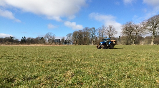 Grasland bemesting met tractor en kunstmeststrooier
