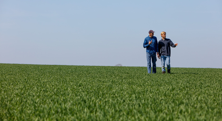 Agronoom en boer lopen over veld