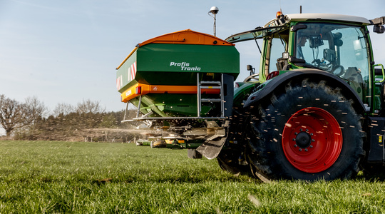 Fendt tractor met kunstmeststrooier op grasland