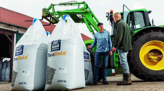 Boer stort kunstmest in strooier