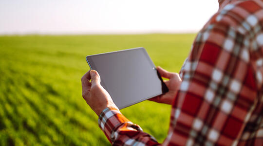 Boer in het land met tablet in handen