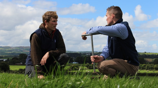 Boeren zitten in het gras met elkaar te praten